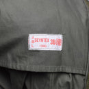 Close-up of white label sewn on olive green fabric of Belgian army field jacket M64 parka from 1990 size large
