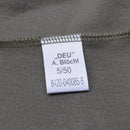 Close-up of white fabric tag on olive Blochl Brand military style thermal high neck jersey shirt with stitching details