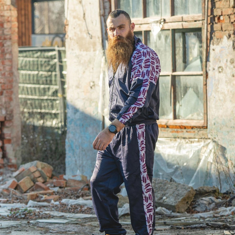Man wearing a vintage 90s retro French military school sports jacket with striped patterned sleeves and pants.