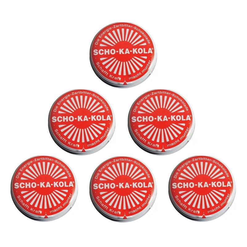 Six tin cans of German SCHO-KA-KOLA dark chocolate with caffeine and cola nut energy boost in red packaging.