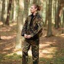 Man wearing MFH Brand U.S. Military style flecktarn camo ripstop jacket and pants standing in forest.
