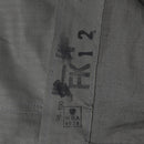 Close-up of vintage Austrian M59 field jacket fabric showing black stenciled military markings and herringbone pattern.