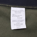Close-up of the original Dutch Military soft shell jacket label showing material and care details in olive fabric.