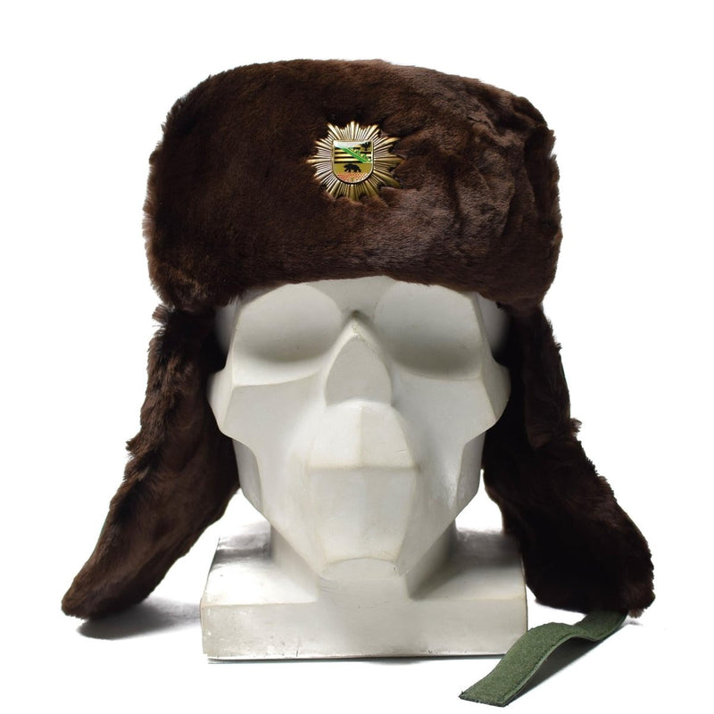 Original German police faux fur ushanka winter hat with ear flaps and badge for cold weather warmth.