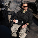 Man wearing original U.S. military digital tiger stripe camo pants sitting outdoors with coffee cup in hand